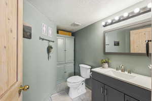 Bathroom featuring a dark gray vanity with a single sink, an overhead vanity light fixture, and a built-in storage cabinet