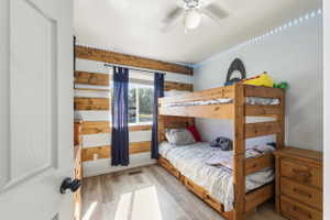 Room featuring wood-finish flooring and a ceiling fan with integrated lighting