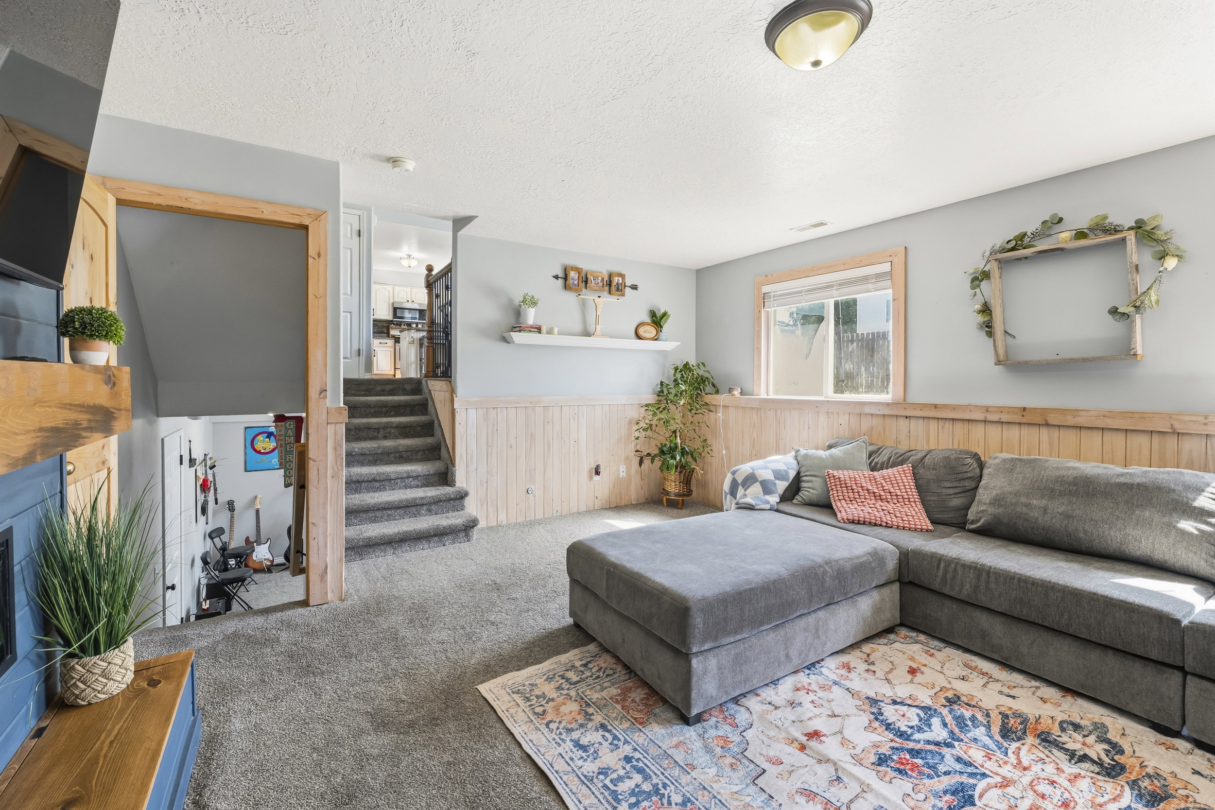 Carpeted living area featuring wainscoting and a recessed window