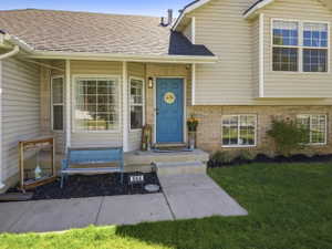 Traditional-style exterior with beige siding, brick accents, and a contrasting blue front door