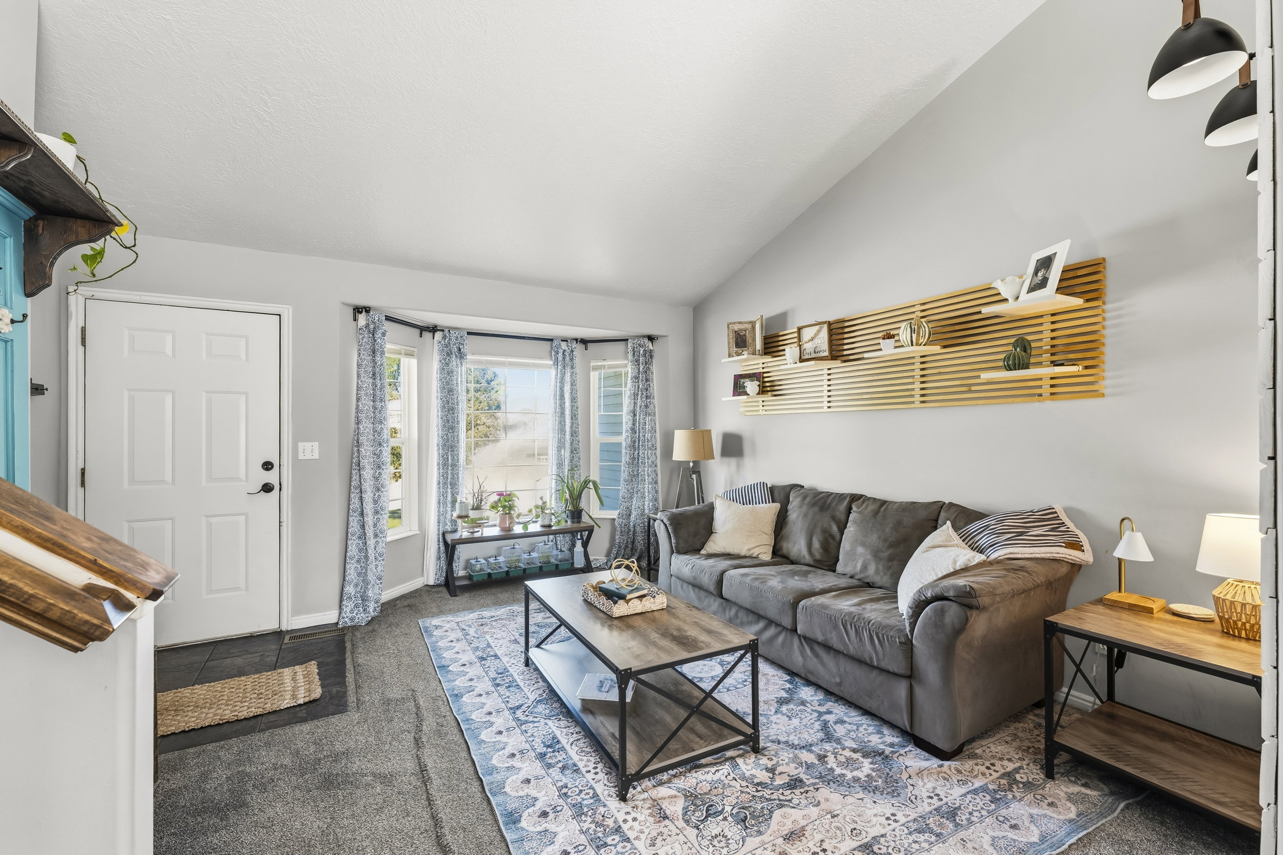 Living area featuring a vaulted ceiling and a bay window with multiple panes
