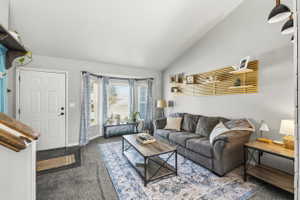 Living area featuring a vaulted ceiling and a bay window with multiple panes