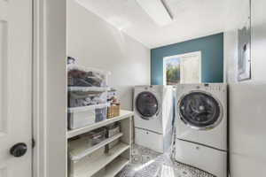 Dedicated laundry area featuring patterned tile flooring, a window, and a built-in shelving unit