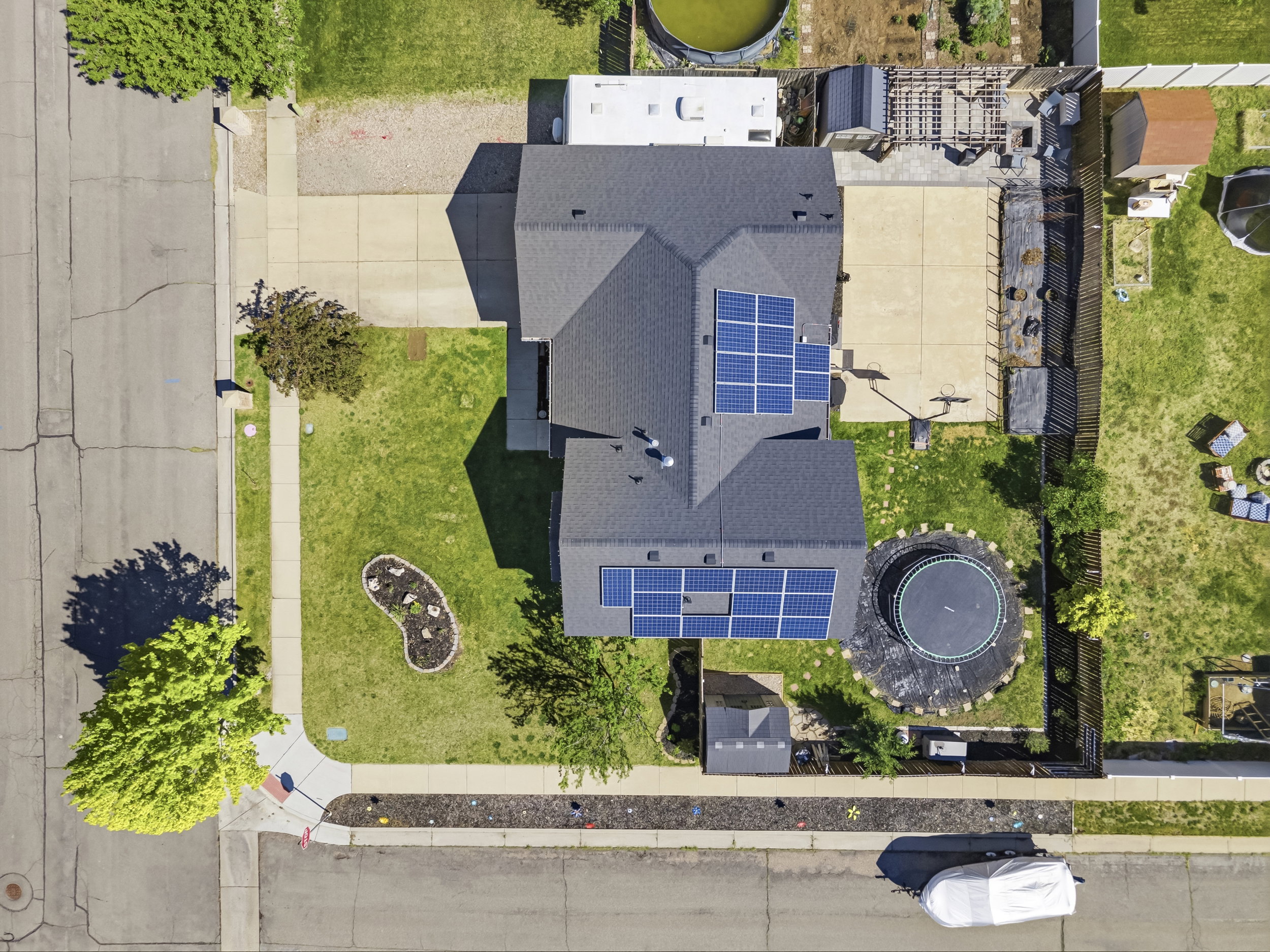 Aerial perspective highlighting a multi-level roofline with multiple solar panel arrays
