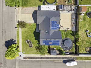 Aerial perspective highlighting a multi-level roofline with multiple solar panel arrays