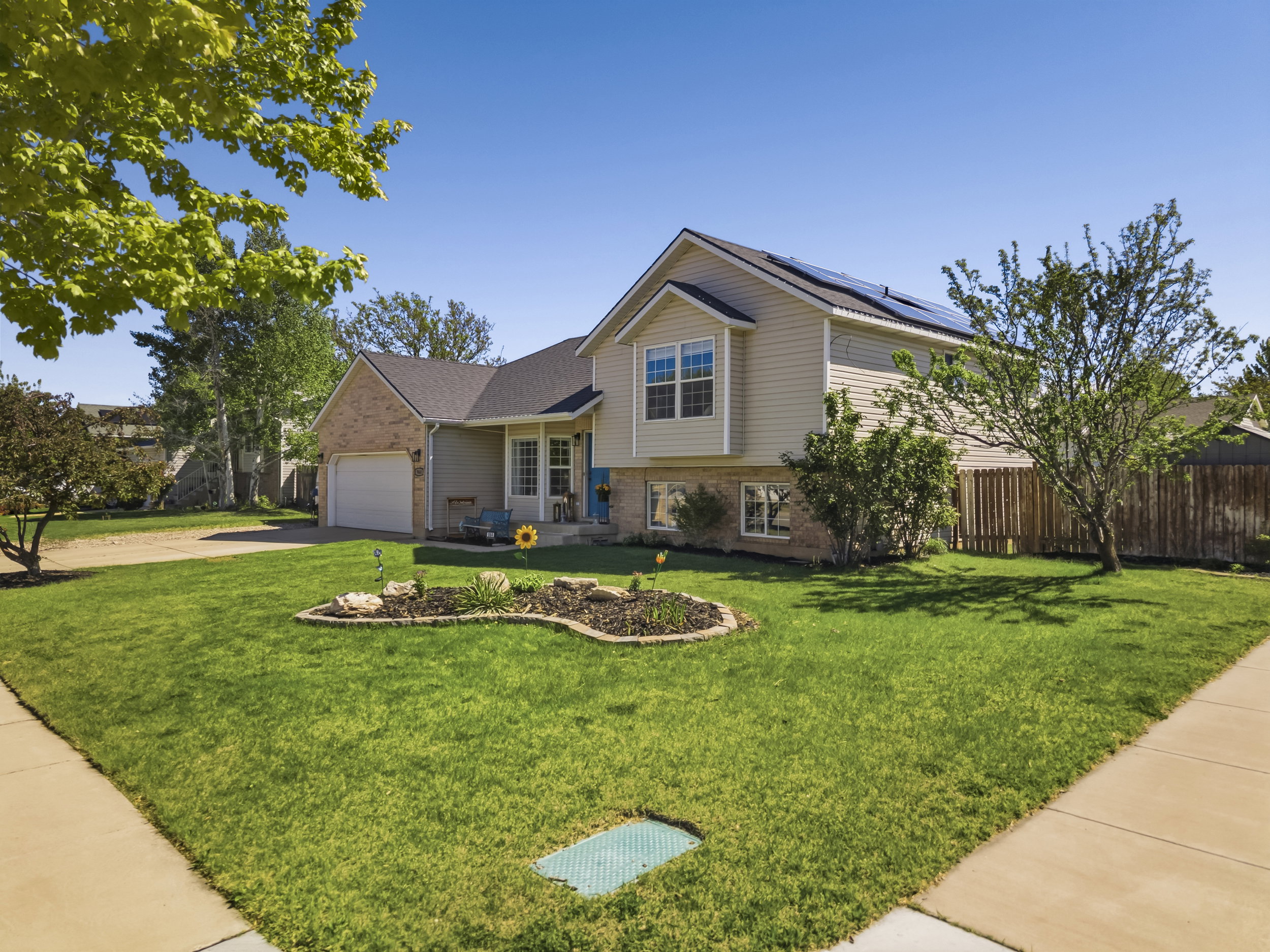 Exterior showcasing a two-story home with a brick and siding facade, an attached garage, and a landscaped front yard