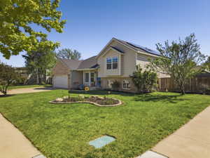 Exterior showcasing a two-story home with a brick and siding facade, an attached garage, and a landscaped front yard