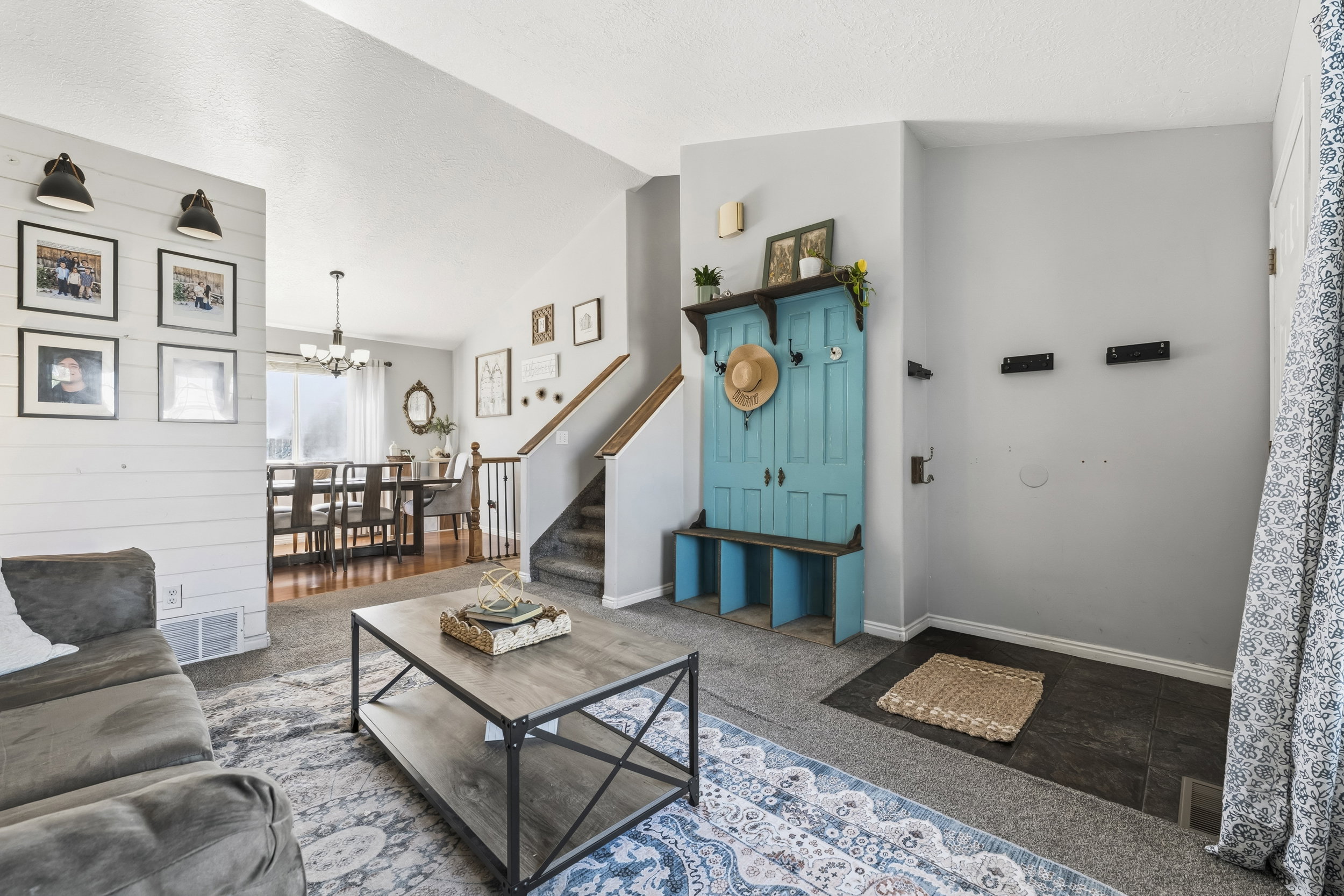 Spacious living area featuring shiplap accent wall, wood-finish flooring, and a dining space