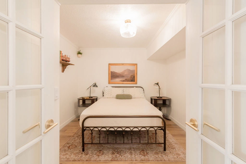 Interior room featuring French doors with brass hardware, light wood-finish flooring, and crown molding