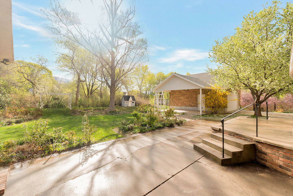 Expansive concrete patio with integrated steps and a metal handrail
