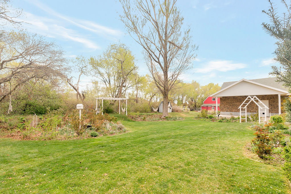 Expansive green lawn with mature trees and established landscaping
