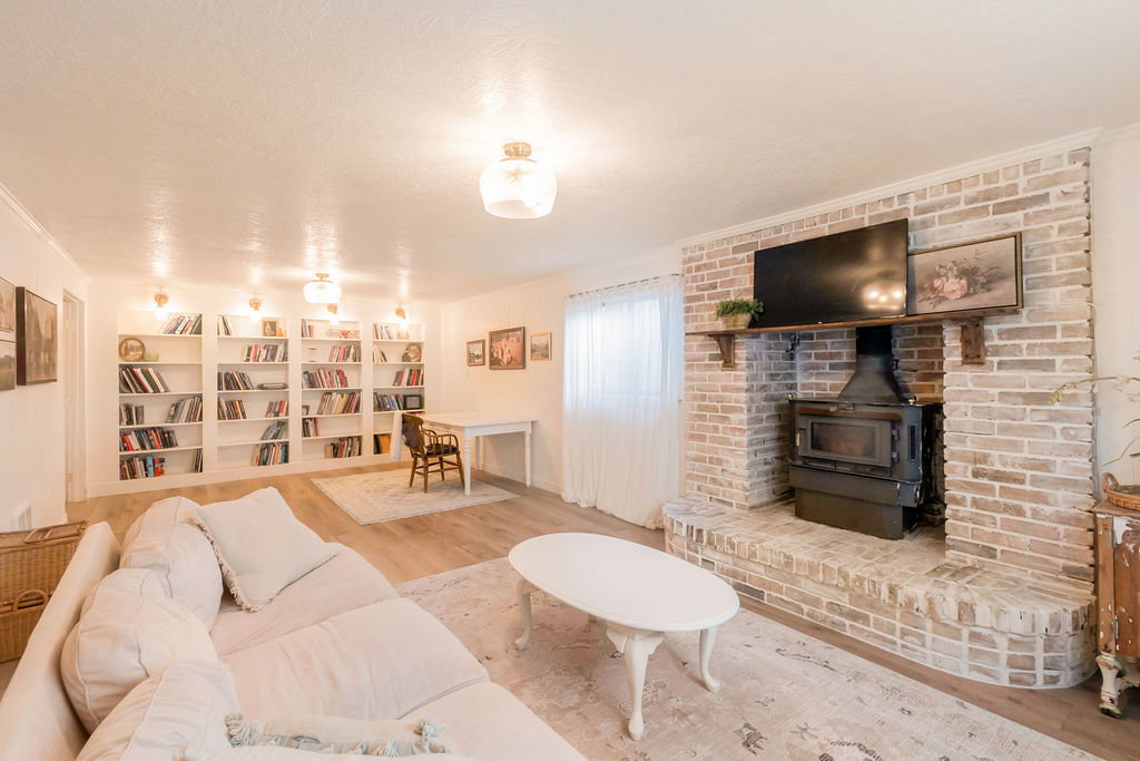 Brick fireplace with a wood-burning stove and a wood mantel