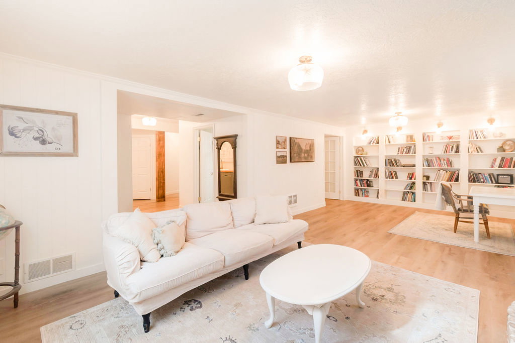 Bright interior space featuring wood-finish flooring, white walls, and crown molding