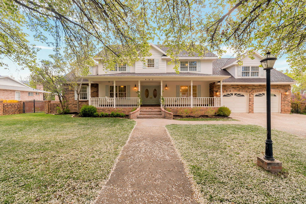 Traditional facade featuring a covered front porch with white railings and columns