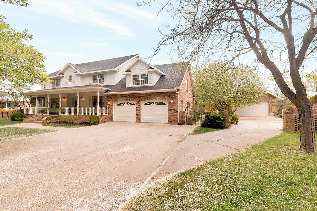 Traditional-style residence featuring a brick and white siding exterior