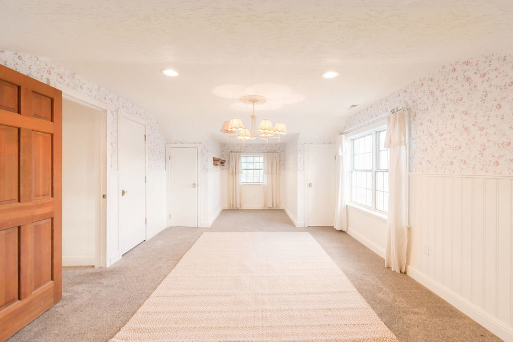 Spacious room featuring carpet flooring and wainscoting