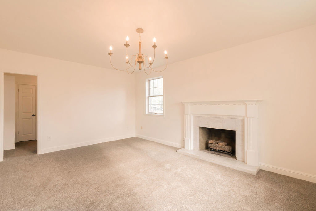 Living room featuring a traditional chandelier, neutral wall paint, and light gray carpeting