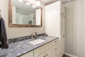 Bathroom vanity featuring an integrated sink, patterned countertop, and brushed nickel faucet