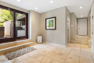 Tiled flooring throughout with recessed lighting, offering a sliding glass door exterior access.  Walk out access
