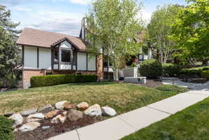 Exterior facade featuring a bay window, stucco siding, and brick accents