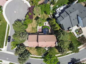 Terracotta-style roofline residence featuring an expansive rear yard, mature landscaping, a sunroom with an arched window design, and an upper-level deck