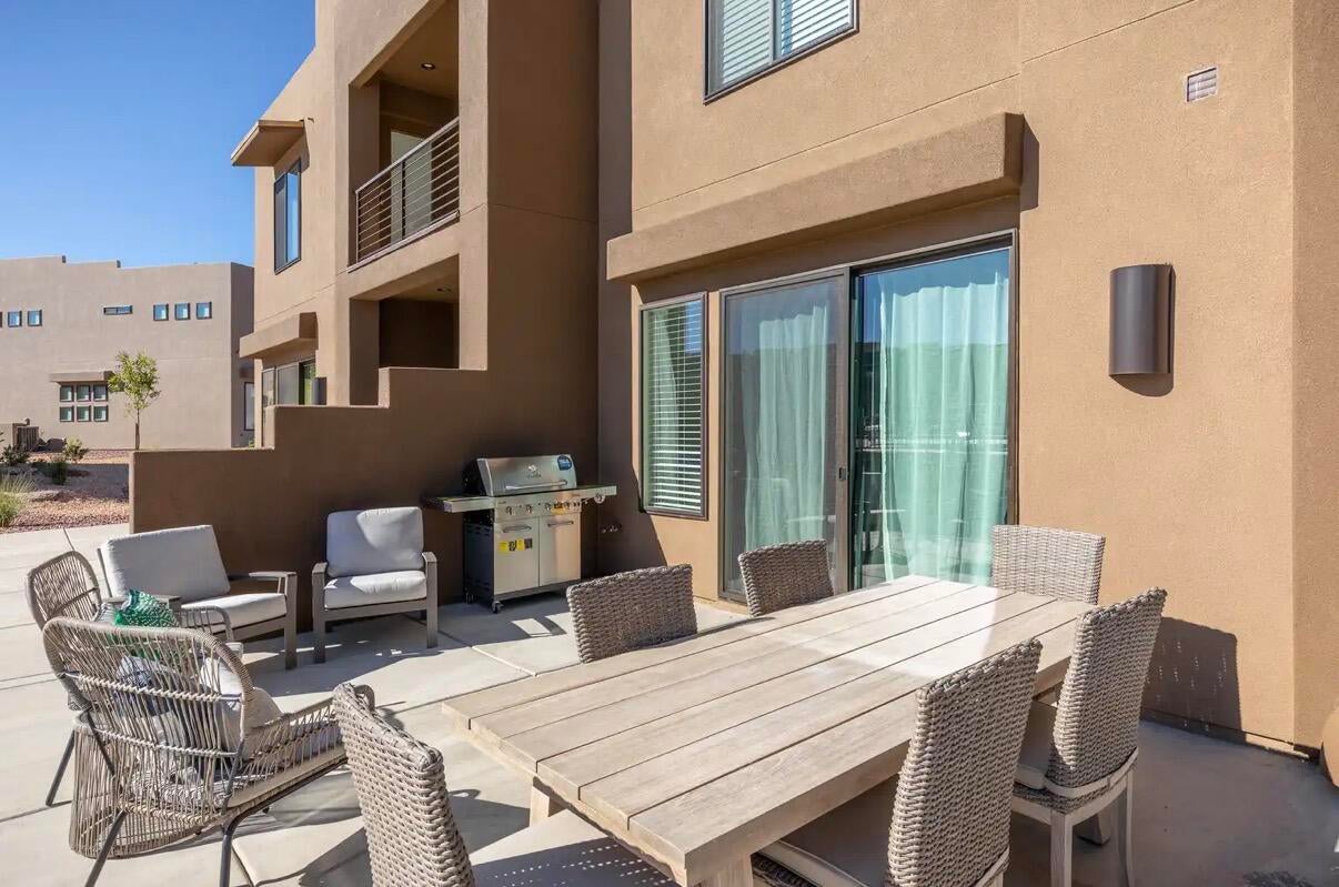 Private patio space featuring a sliding glass door entry, exterior wall sconce, and stucco exterior