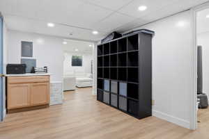 Finished basement area with wood-finish flooring, recessed lighting, and white walls