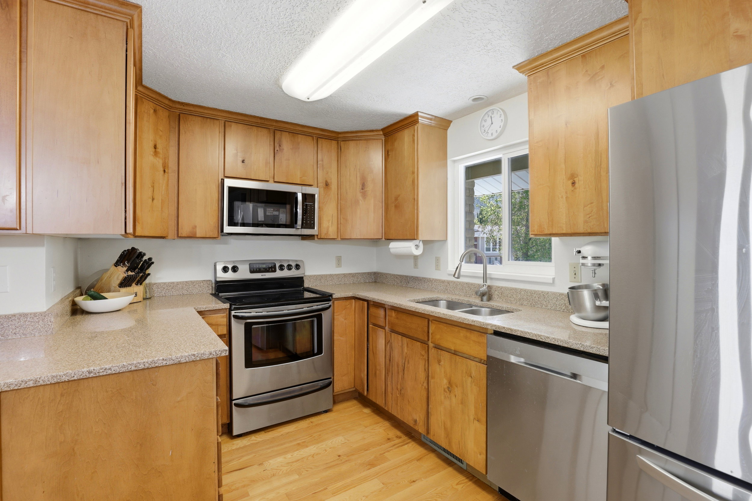 Kitchen featuring wood-finish cabinetry, light-toned countertops, and stainless steel appliances