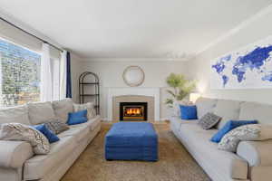 Living room featuring a fireplace with a white mantel, tile surround, and an integrated firebox