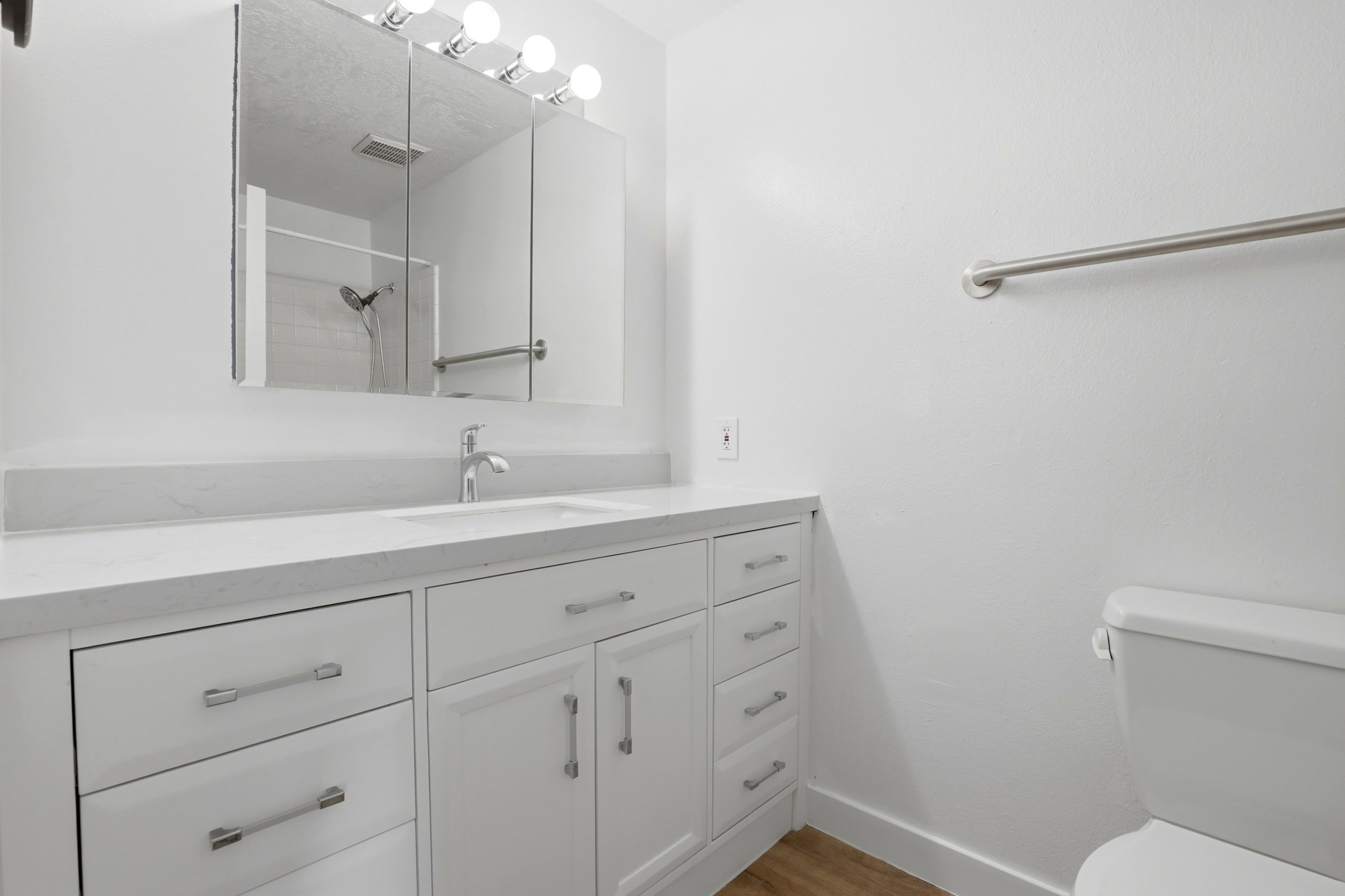 White vanity featuring a single sink and brushed nickel faucet