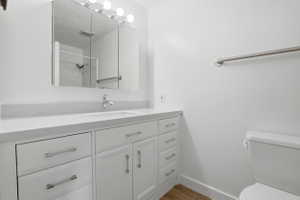 White vanity featuring a single sink and brushed nickel faucet