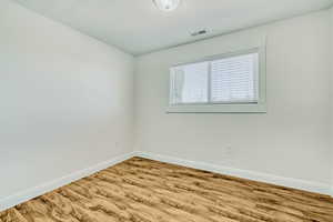 Interior space featuring wood-finish flooring, white baseboards, and neutral wall paint