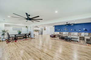 Open-concept living space featuring wood-finish flooring, recessed lighting, and dual ceiling fans