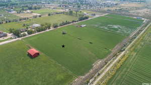 Expansive green fields with a red barn structure
