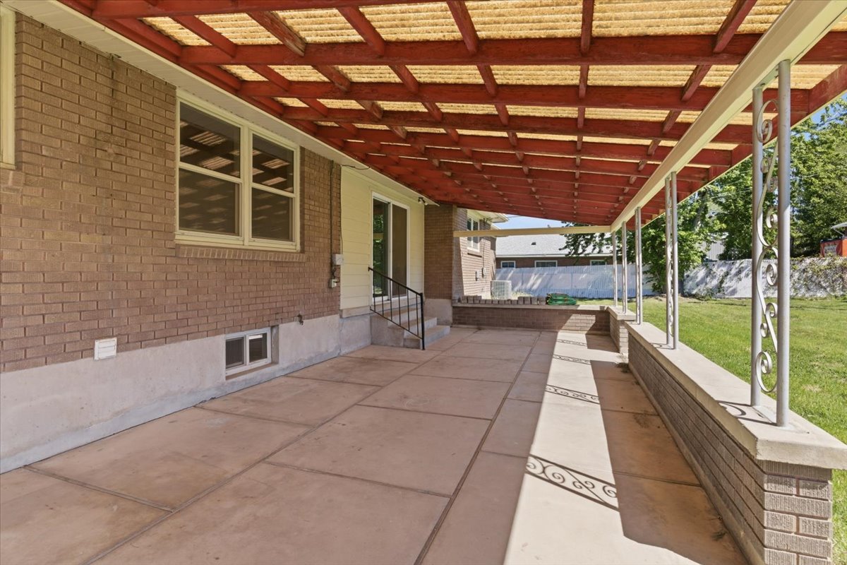 Expansive covered patio featuring a concrete slab, and decorative metal support columns