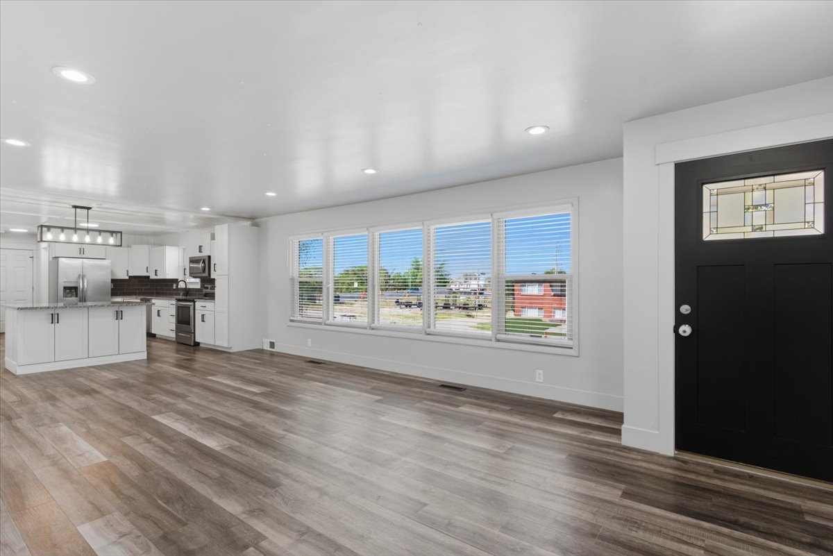 Open-concept living space featuring vinyl flooring, recessed lighting, and updated kitchen