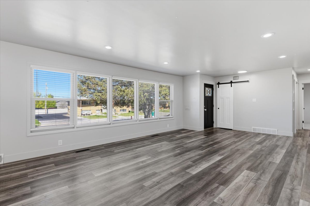 Spacious room featuring vinyl flooring, recessed lighting, and large windows with blinds