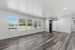 Spacious room featuring vinyl flooring, recessed lighting, and large windows with blinds