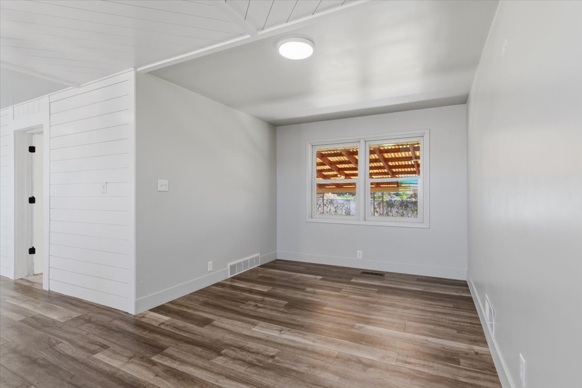 Interior space featuring vinyl flooring, large windows, and a white shiplap accent wall