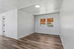 Interior space featuring vinyl flooring, large windows, and a white shiplap accent wall