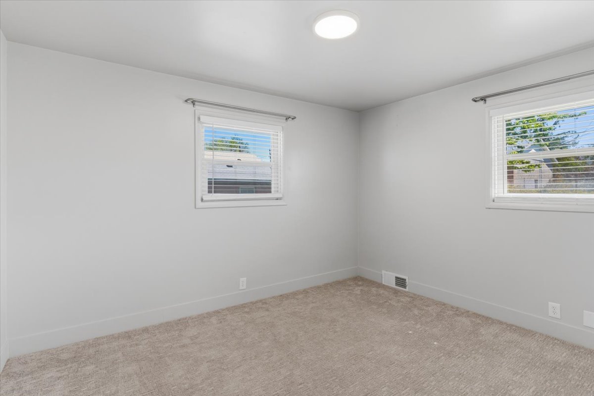 Carpeted bedroom with light grey walls and white trim