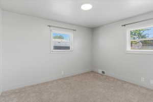 Carpeted bedroom with light grey walls and white trim