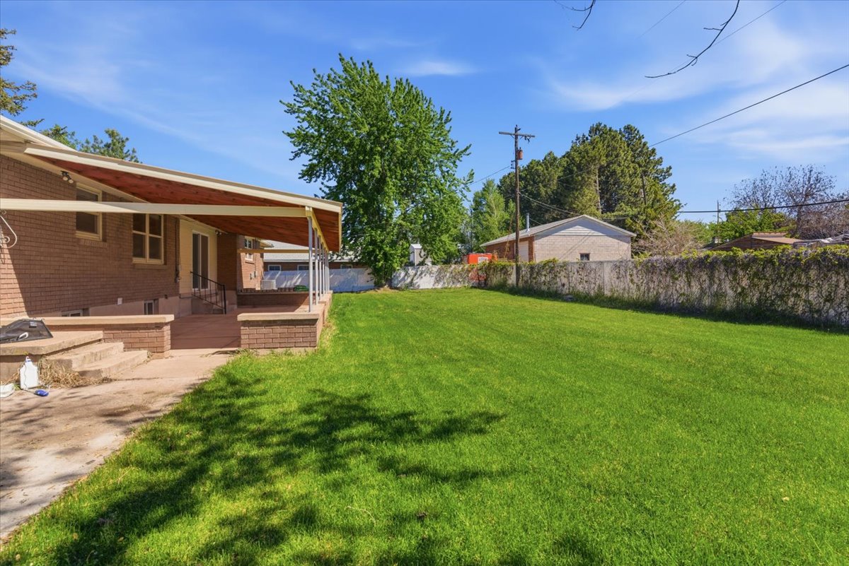 Expansive green lawn with a covered patio