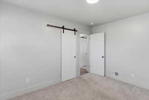 Bedroom featuring light gray walls, plush gray carpeting, and white trim