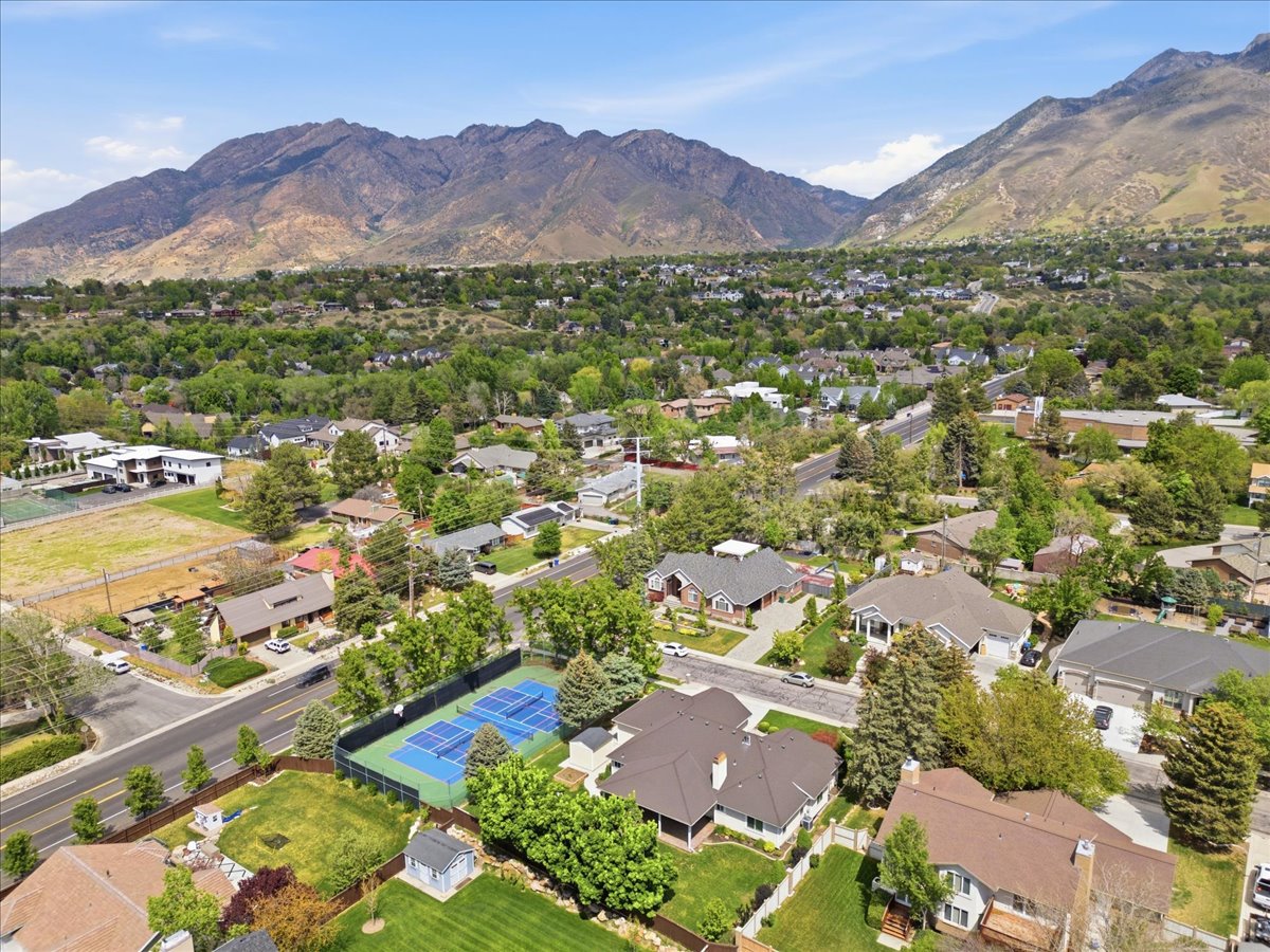Residential neighborhood featuring mature trees and mountain scenery