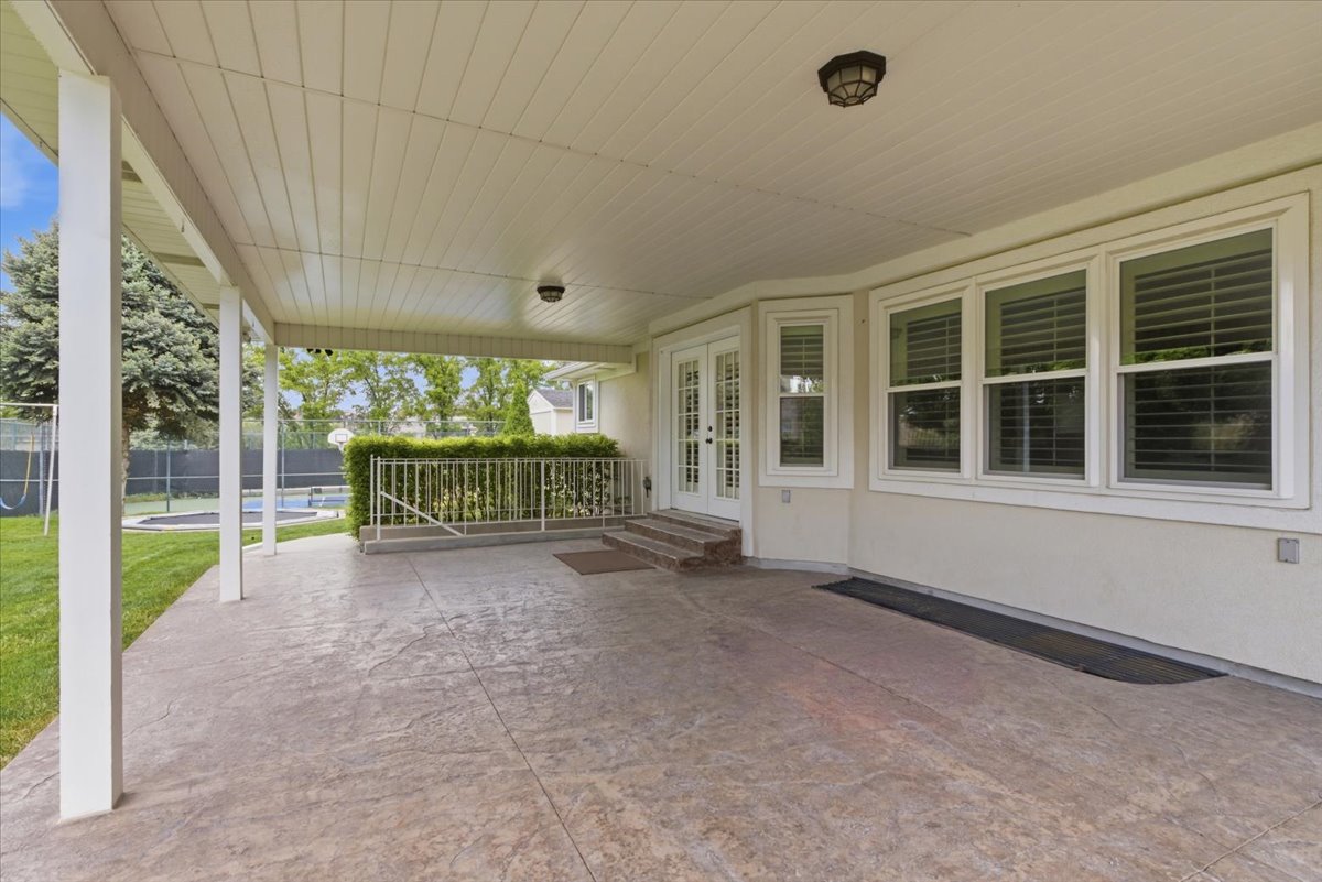 Expansive covered patio featuring a stamped concrete surface and white support columns