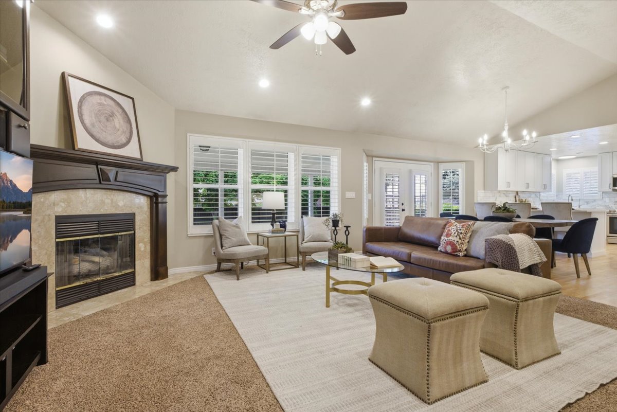 Spacious living area featuring a fireplace with a dark wood mantel and stone surround