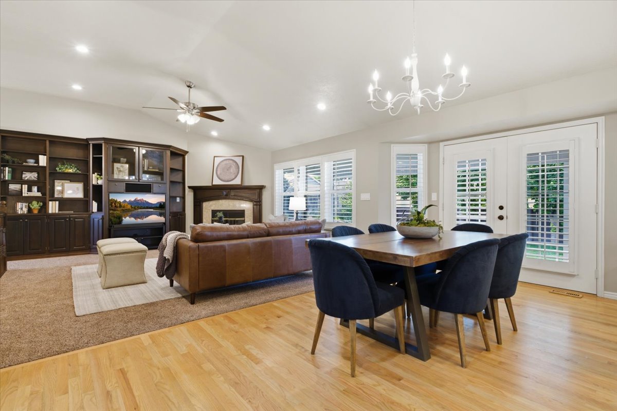 Open-concept living space with light wood-finish flooring, vaulted ceilings, and recessed lighting