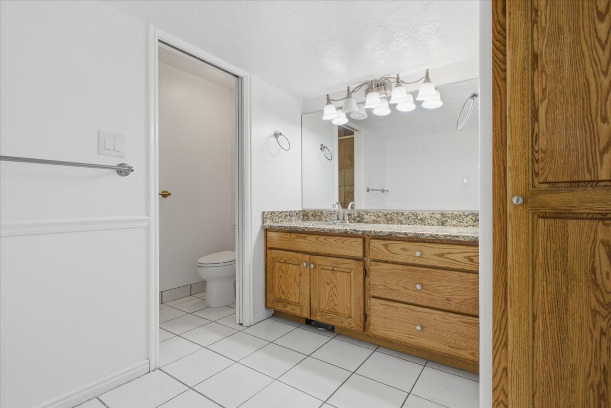 Bathroom vanity featuring a light wood-finish cabinet with multiple drawers and cabinet doors