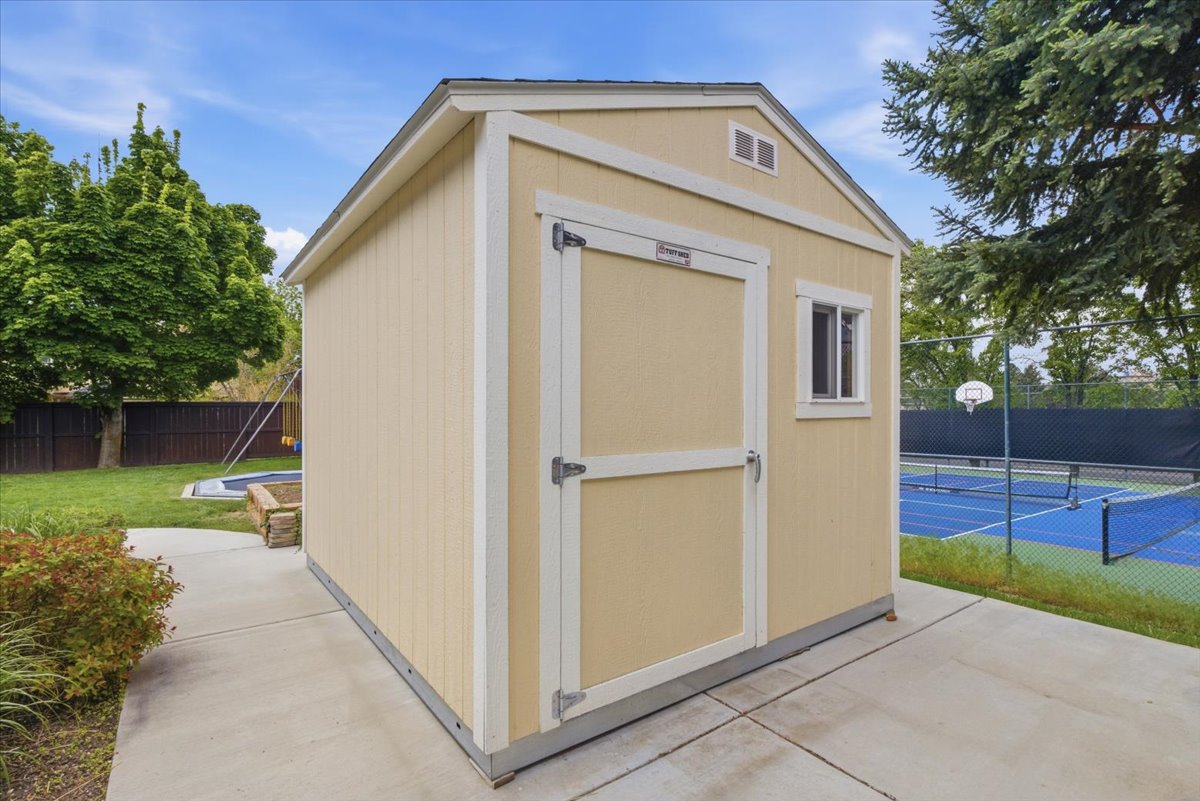 Outdoor storage shed featuring a single window and gable vent